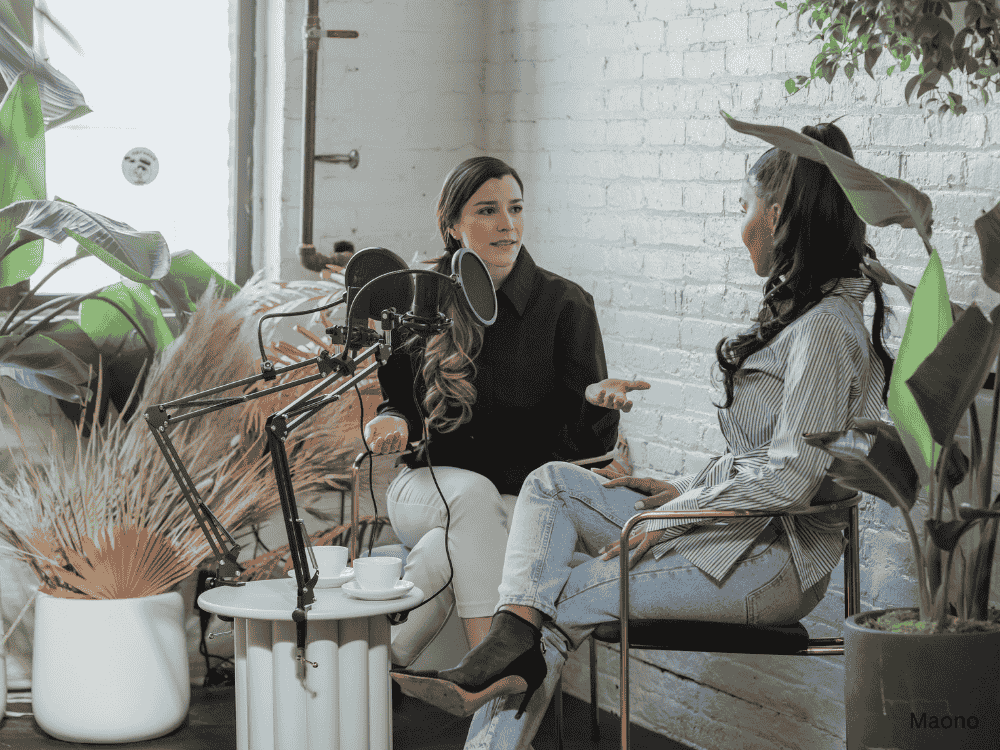 Two women chatting during podcast using a podcasting microphone