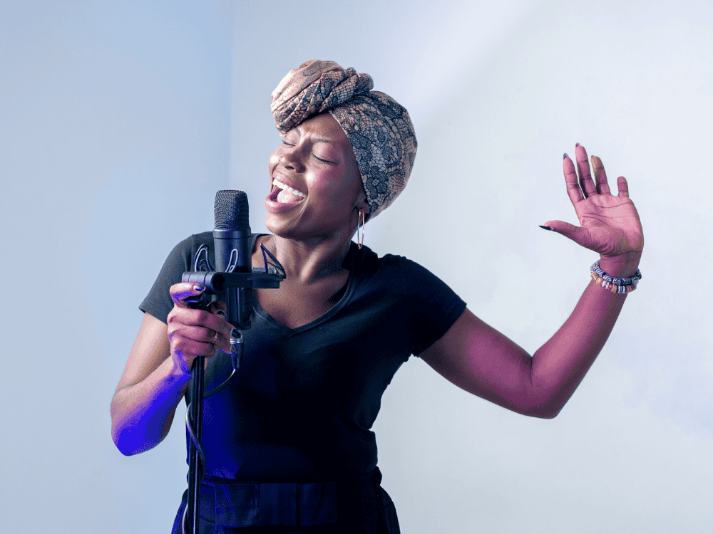 A lady singing in studio using a condenser microphone for singing