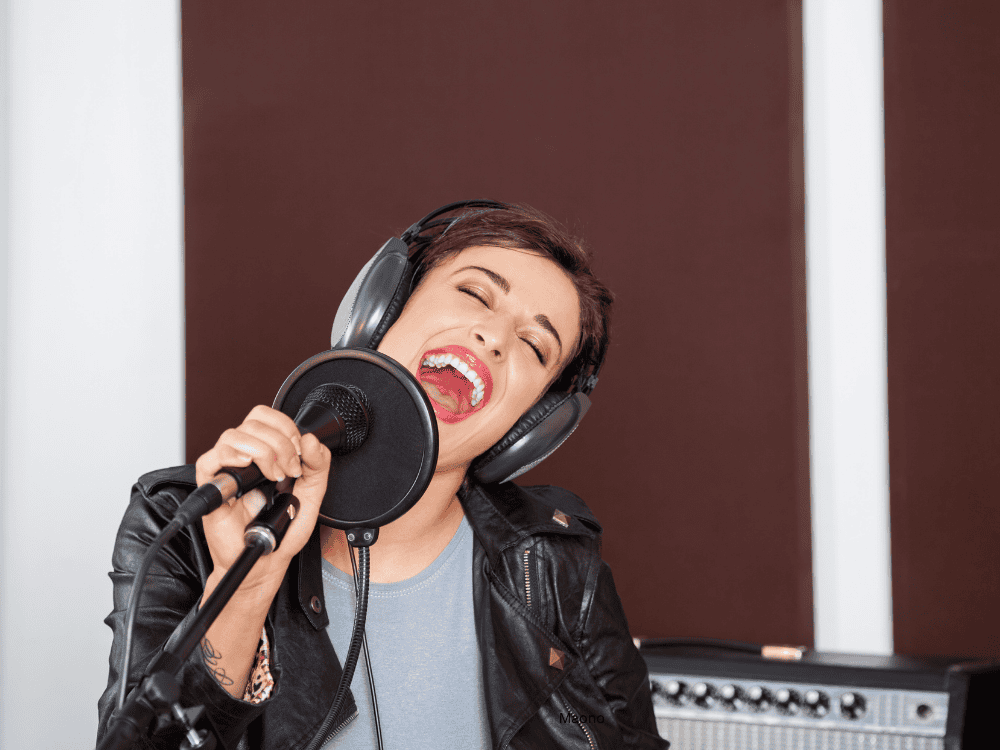 A woman recording in a studio using a professional singing microphone