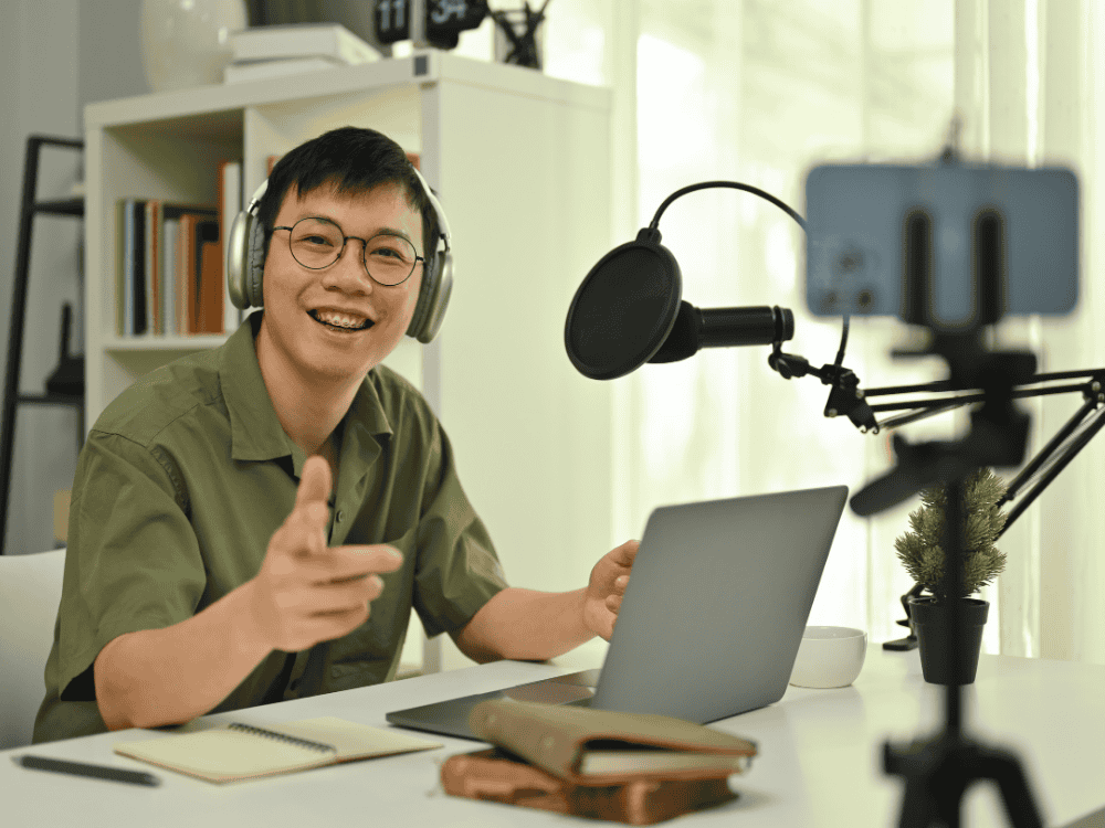 A male recording a vlog using a studio microphone condenser