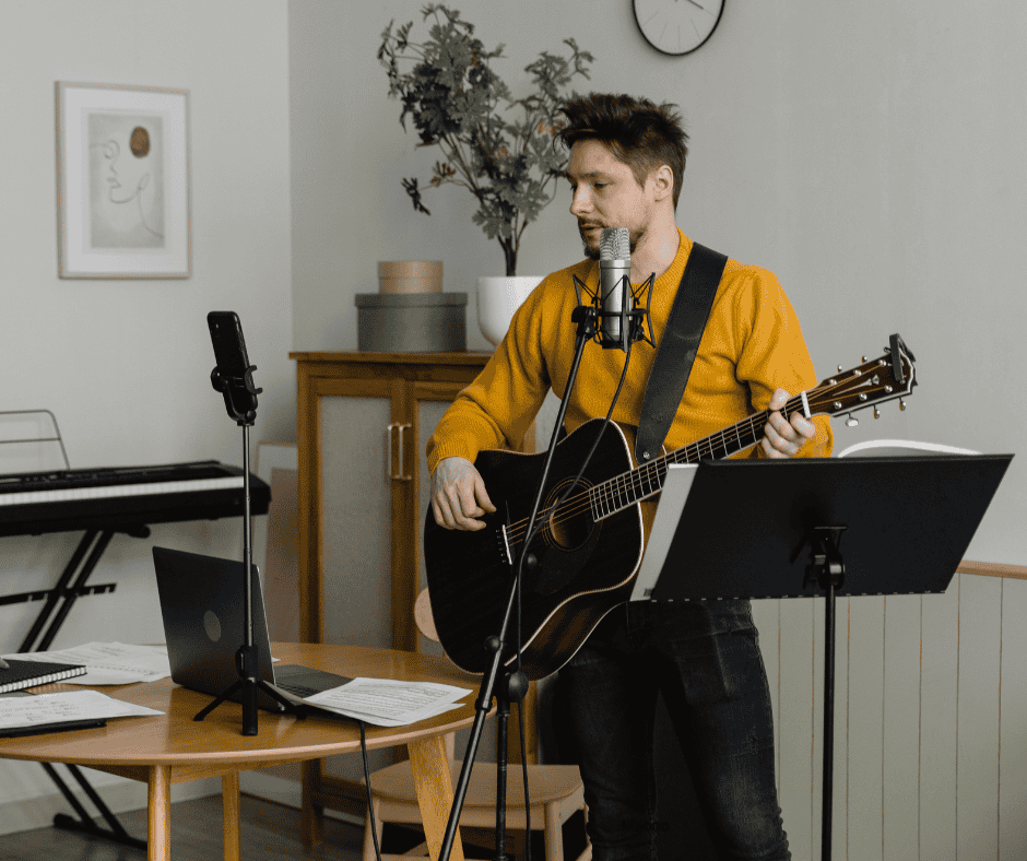 A man recording music and vocals using a recording microphone