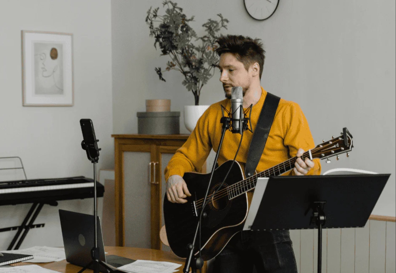 A man recording music and vocals using a recording microphone