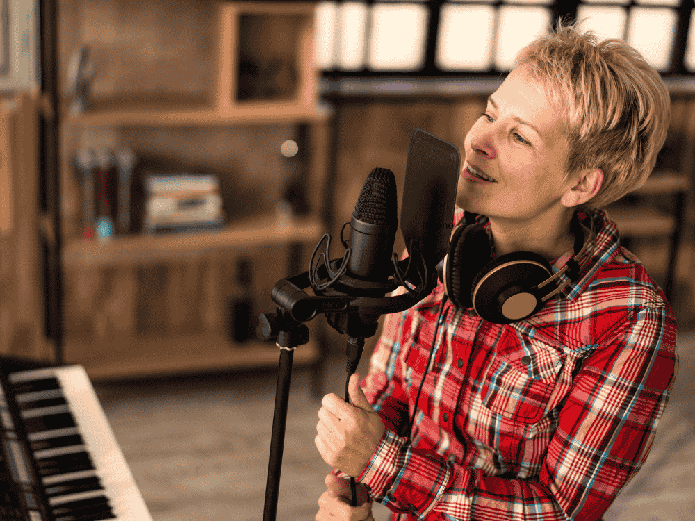 A vocalist singing in studio using one of the best singing microphone options in her home studio