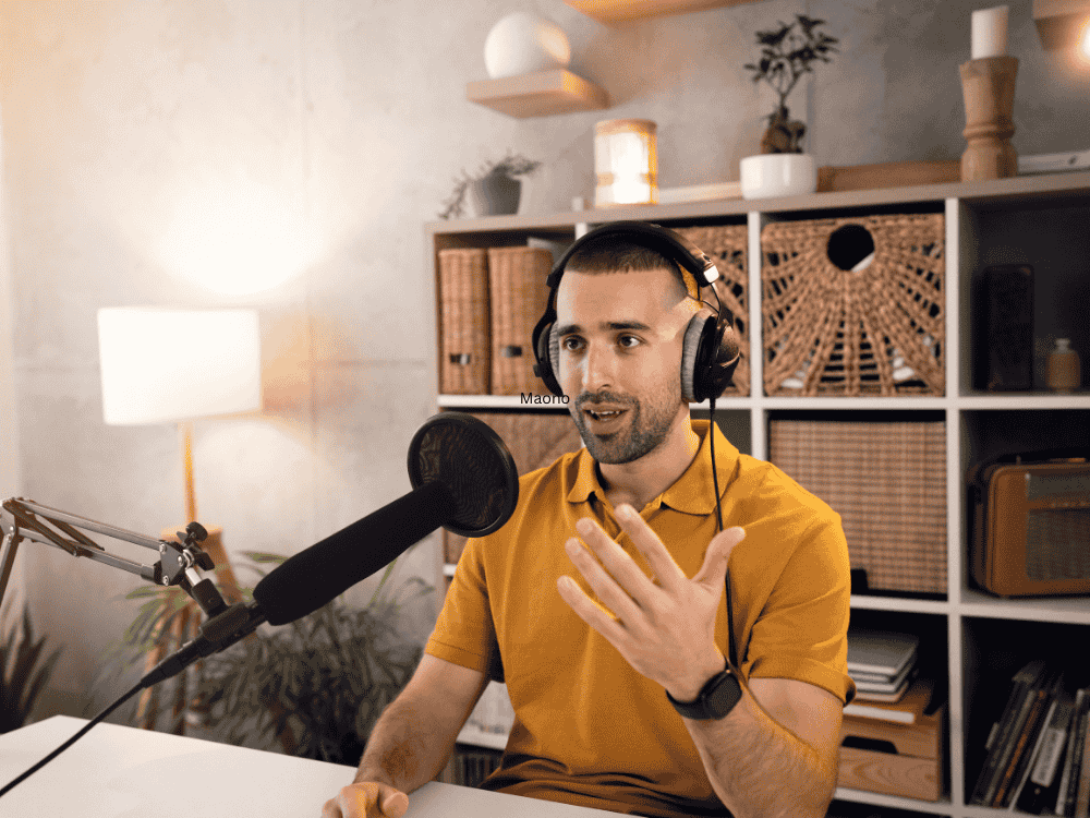 A male podcaster using a podcast microphone while recording podcast in home studio