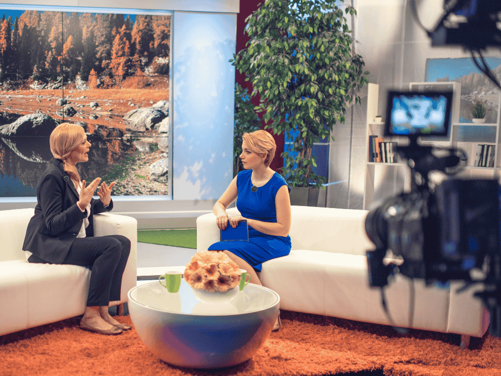 Two female broadcasts using a wireless microphone lavalier for their live talk show