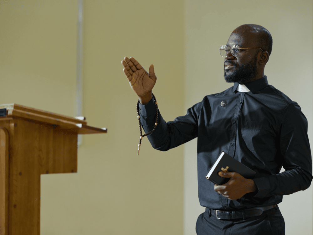 A pastor during a sermon using a wireless microphone to amplify his voice