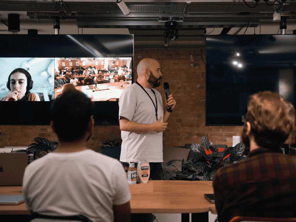 Remote workers using a condenser microphone during a Zoom call with teammates