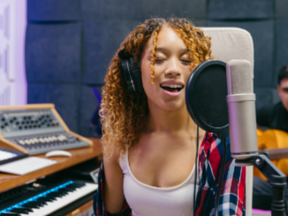 girl singing in a studio using a professional condenser microphone