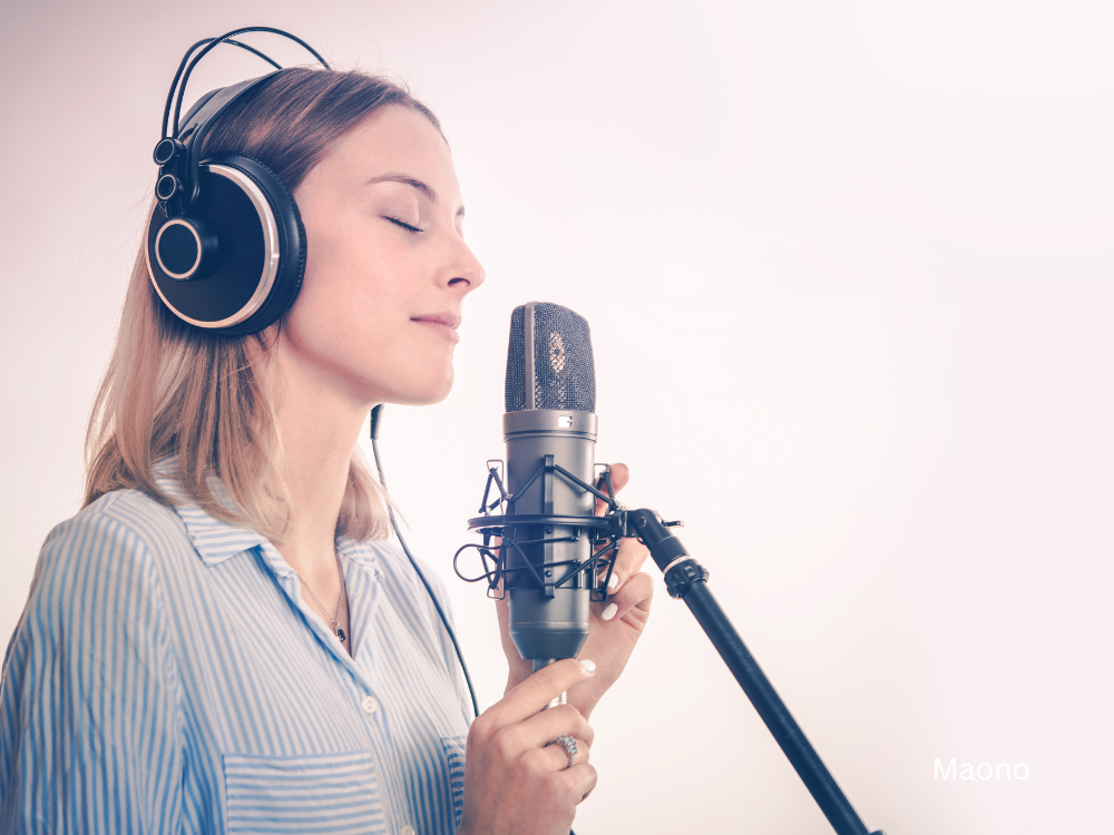 female recording at a home studio using a microphone