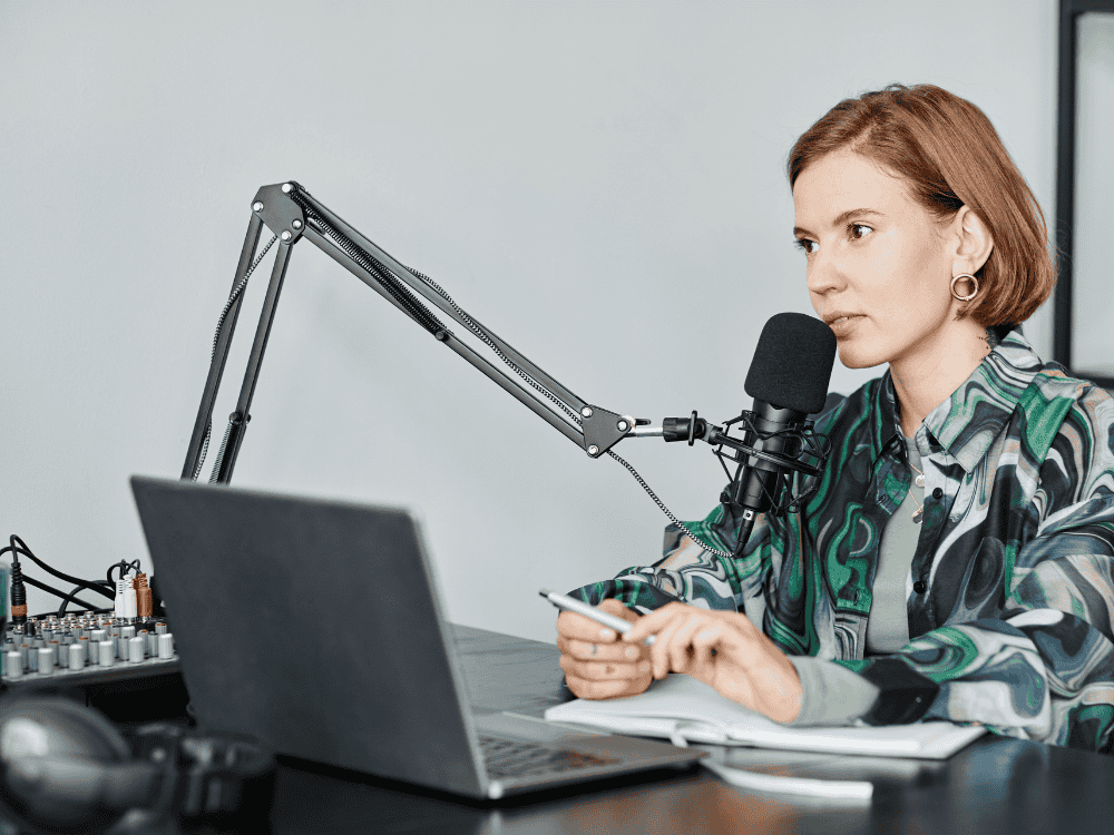 woman podcasting using microphone and audio mixer